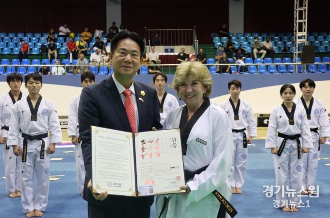 이동섭 국기원장(왼쪽)이 제인 넬슨 국무장관(오른쪽)에게 명예 5단증을 수여하고 기념사진을 촬영하고 있는 모습.