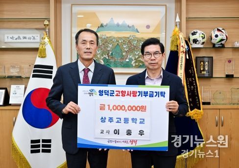 상주고등학교 이충우(왼쪽) 교사가 김광열 영덕군수에게 고향사랑 기부금을 전달하고 있다.