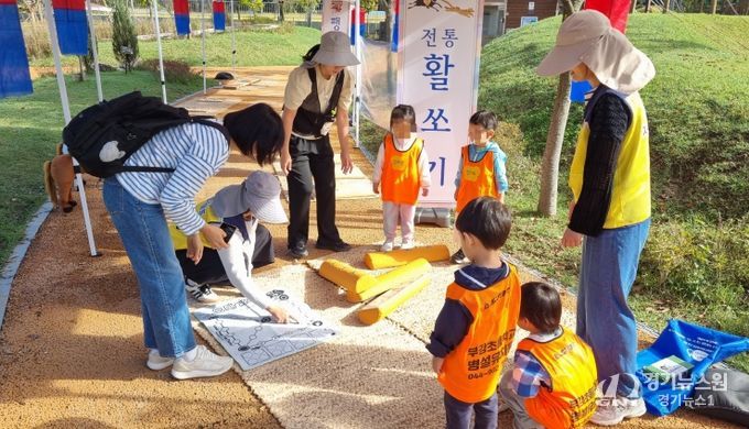 23일 무지개 축제에서 아이들이 활쏘기 체험과 멧돌을 체험해 보고 있는 모습