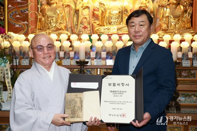 울산 동구 대한불교조계종 등용사(주지스님 본명)가 소장하고 있는 ‘대혜보각선사서’가 국가지정 보물로 지정된 가운데 등용사 법당에서 김종훈 동구청장과 주지스님이 대혜보각선사서와 보물지정서를 들고 기념촬영하고 있다.