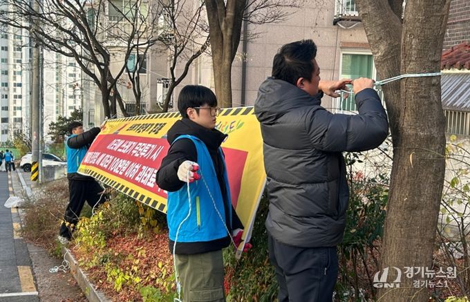 서경대학교 학생들이 무단투기 금지 현수막을 달고 있다.
