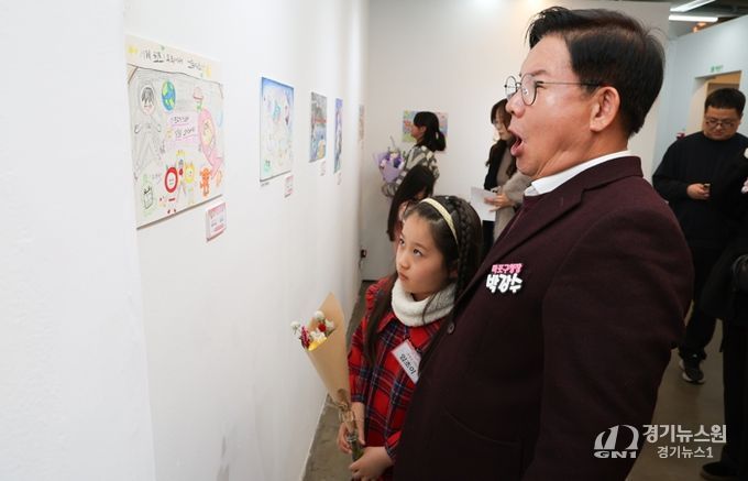 박강수 마포구청장이 수상 어린이와 함께 전시된 그림을 살펴보고 있다.
