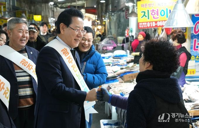 김영록 전라남도지사가 설 명절을 앞둔 15일 지역 전통시장인 광주 양동시장을 방문해 전남·광주 행정통합의 취지와 추진 방향을 설명하고 물품을 구매하며 상인들을 격려하고 있다.