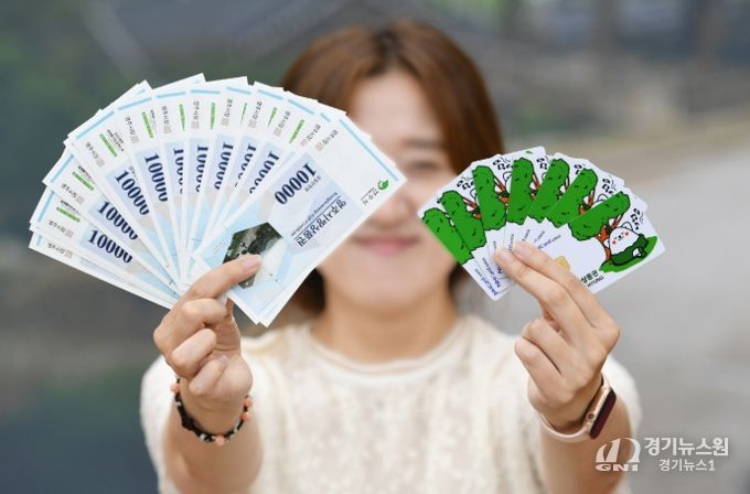 영주사랑상품권은 3월 1일부터 영주사랑상품권 할인율을 12%로 상향한다(영주사랑상품권.체크카드를 들고 있는 시민 모습)